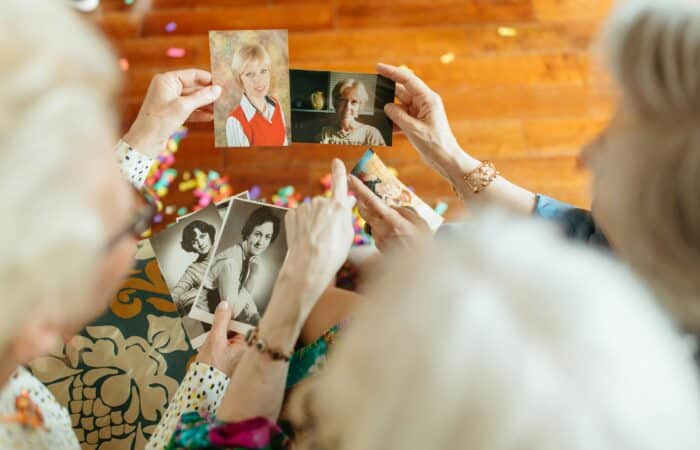 Three old friends looking at images of their past. Something that helps people living with dementia reminisce about the good old times.