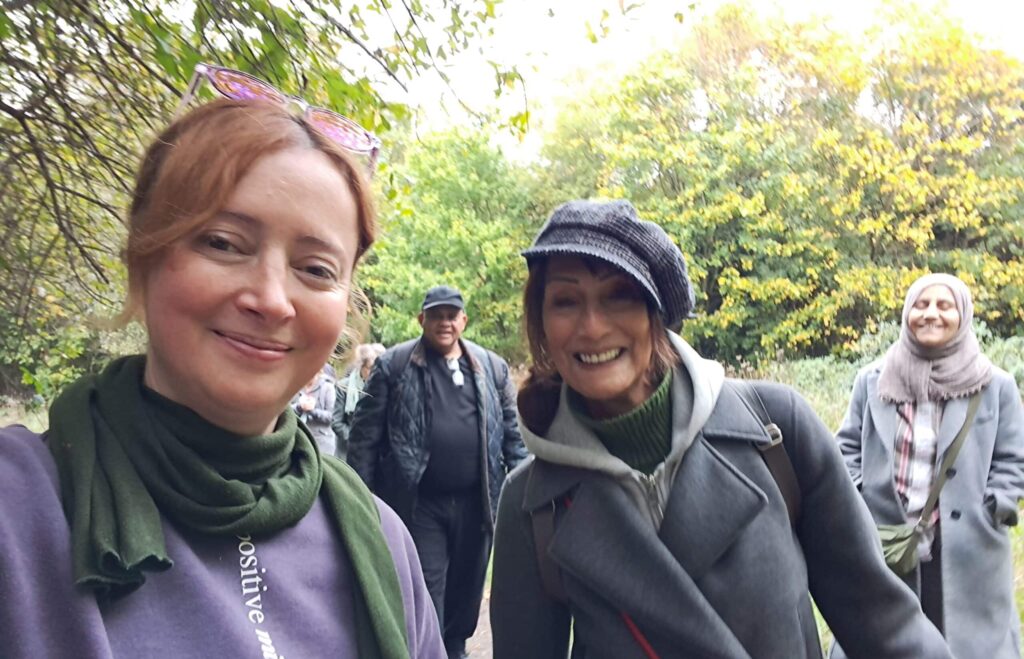 Smiling people on a walk in the woods looking at the camera
