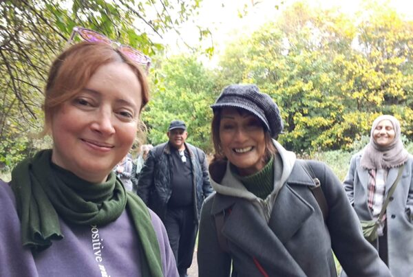 Smiling people on a walk in the woods looking at the camera