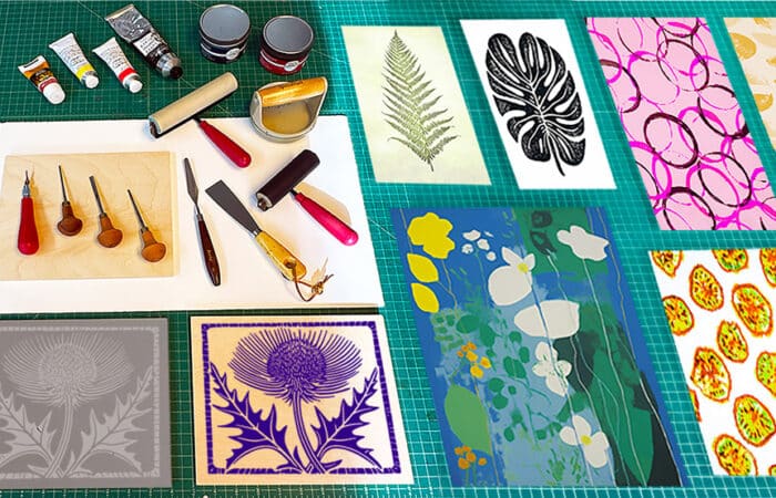 4 prints of leaves in different colours laid out on a table next to hand rollers and paints.