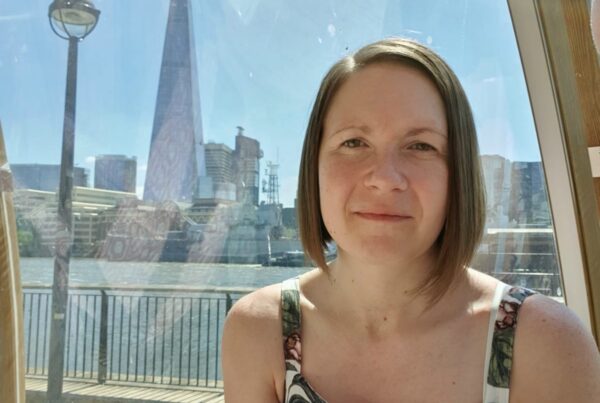 Woman smiling with the Shard in teh distance behind her.